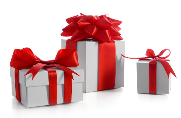 Cajas de regalo decoradas con cinta roja y lazo grande aislado en blanco