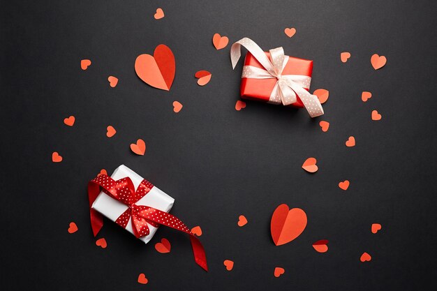 Cajas de regalo del día de San Valentín con corazones rojos sobre fondo de papel negro