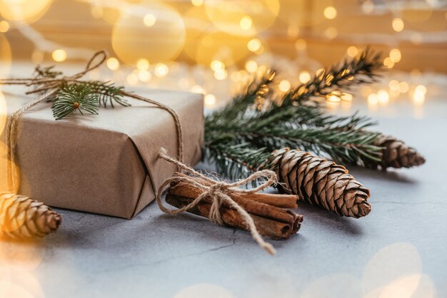 Cajas de regalo de embalaje ecológico navideño envueltas en papel kraft con piñas, decoración ecológica de madera y luces navideñas