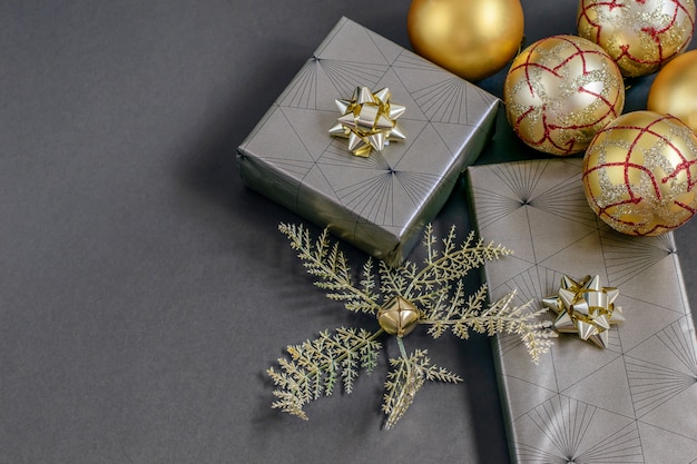 Cajas de regalo de envoltura artesanal de Navidad y año nuevo, cintas doradas, bolas y adornos en el negro.