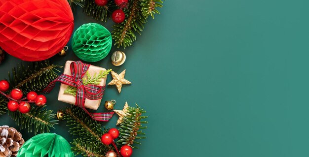 Cajas de regalo envueltas entre adornos navideños y ramas de abeto verde en espacio de copia verde