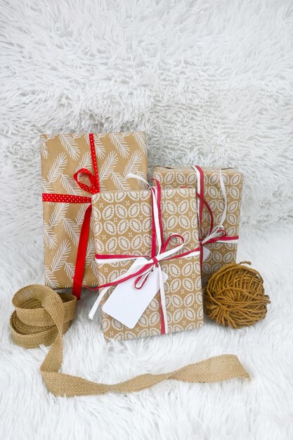 Cajas de regalo envueltas en papel artesanal marrón y atadas con cuerda de yute tarjeta de etiqueta cinta de saqueo sobre fondo blanco cordel arco vista superior espacio de copia idea de regalo dar decoración de regalo