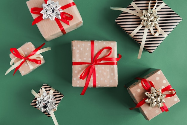 Cajas de regalo envueltas en papel kraft sobre fondo verde. Regalos de Navidad Envoltorio de bricolaje