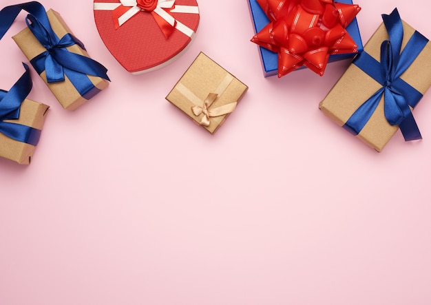 Cajas de regalo envueltas en papel marrón y atadas con un lazo rojo y azul.