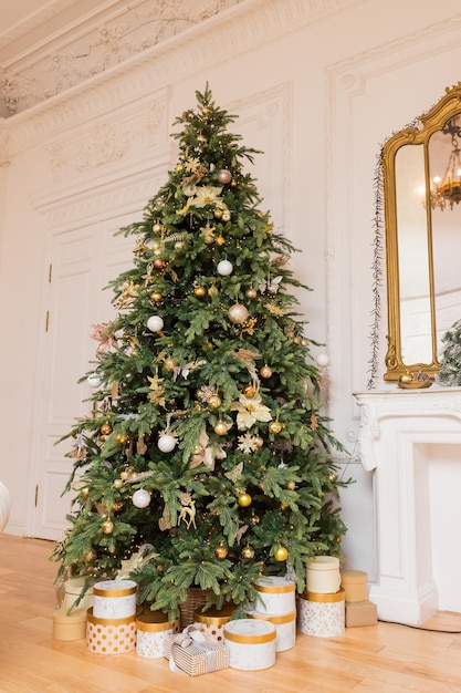 Cajas de regalo de lujo bajo el árbol de Navidad Decoraciones caseras de Año Nuevo envolviendo regalos dorados del árbol festivo de Santa decorado con guirnaldas y bolas brillantes vacaciones de invierno