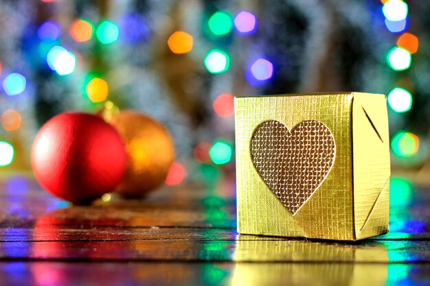 Cajas de regalo en mesa de madera, decoración navideña, luces borrosas en el fondo