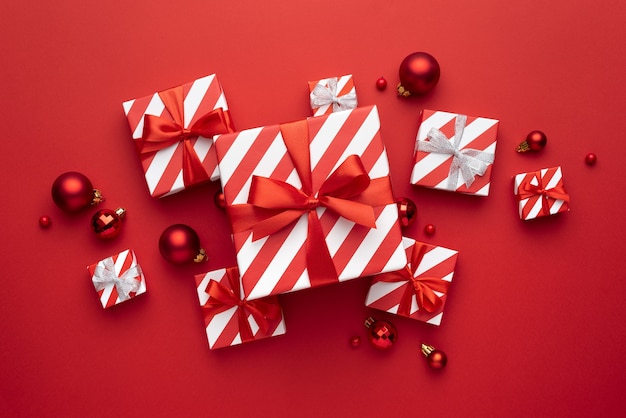 Cajas de regalo de Navidad y adornos para árboles sobre fondo rojo.