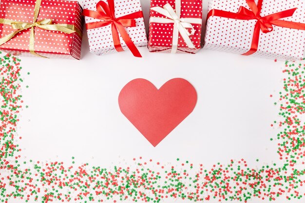 Cajas de regalo de Navidad con cintas, tarjeta en forma de corazón y destellos en blanco