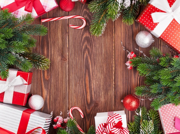 Cajas de regalo de Navidad, decoración y rama de abeto en mesa de madera. Vista superior con espacio de copia.