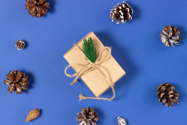 Cajas de regalo de Navidad envueltas en papel artesanal sobre un fondo azul con adornos navideños. Vista superior, vacaciones y concepto de Navidad.