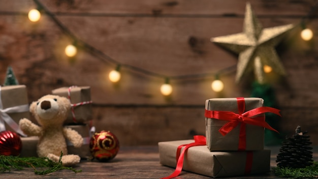 Cajas de regalo de Navidad y osito de peluche en mesa de madera.