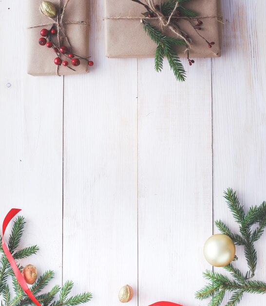 Cajas de regalo de Navidad y rama de abeto en la mesa de madera plana Fondo de Navidad