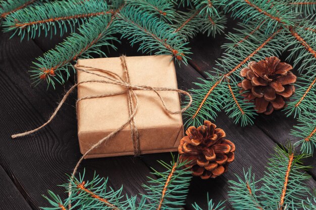 Cajas de regalo de la navidad y rama de árbol de abeto en la tabla de madera.