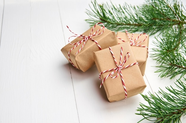 Cajas de regalo de Navidad con ramas de pino en blanco