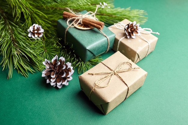 Cajas de regalo de Navidad y ramas de pino con decoración sobre fondo verde