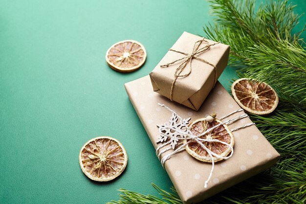 Cajas de regalo de Navidad y ramas de pino con decoración sobre fondo verde