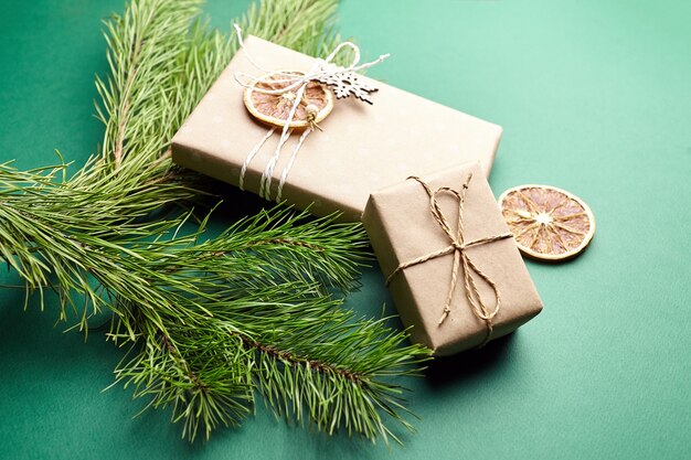 Cajas de regalo de Navidad y ramas de pino con decoración sobre fondo verde