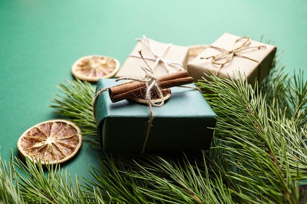 Cajas de regalo de Navidad y ramas de pino con decoración sobre fondo verde