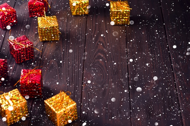 Cajas de regalo de la Navidad en la tabla de madera con nieve.