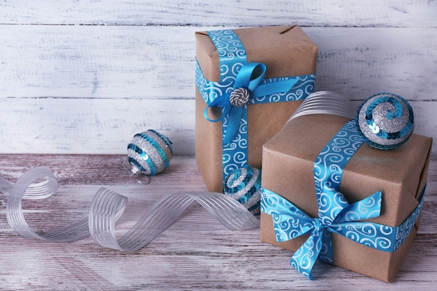 Cajas de regalo navideñas decoradas con cinta azul en la mesa en la pared de madera