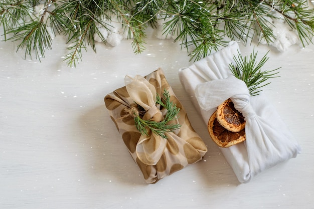 Cajas de regalo navideñas hechas a mano envueltas en tela textil al estilo tradicional japonés furoshiki.