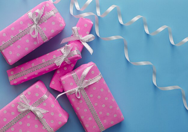 Cajas de regalo o regalo rosa con cinta sobre fondo azul pastel