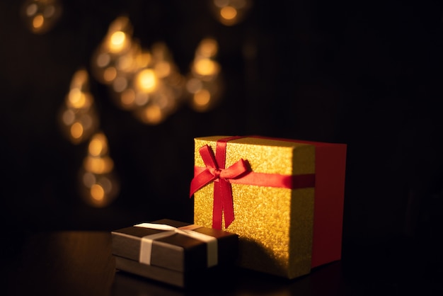 Cajas de regalo en la oscuridad con luces bokeh de una guirnalda de Navidad