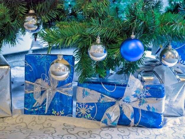 Cajas de regalo de Papá Noel adornadas bajo el árbol de navidad con bolas decorativas