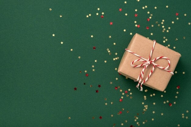 Cajas de regalo en papel artesanal con cinta blanca y roja de Año Nuevo y estrellas de confeti doradas