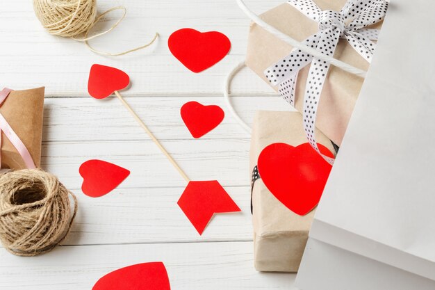 Cajas de regalo, papel cortado corazón y bolsa de compras en blanco
