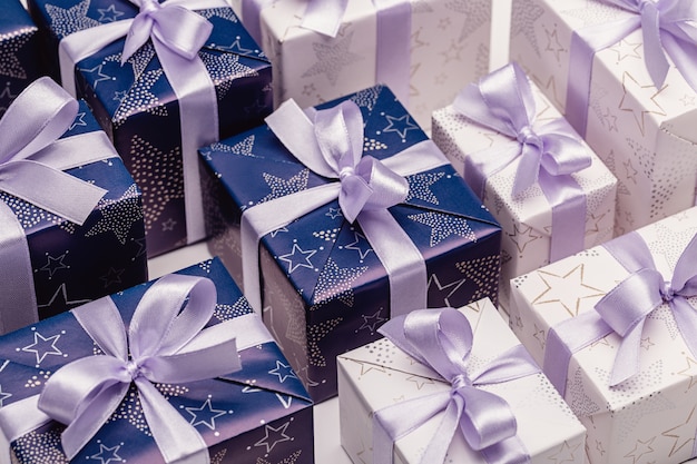 Cajas de regalo en papel elegante con cintas lilas. Felices vacaciones.