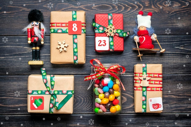 Cajas de regalo rojas verdes envueltas a mano decoradas con cintas, copos de nieve y números