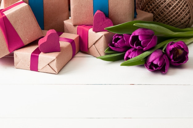 Cajas de regalo románticas con flores en la pared de madera blanca