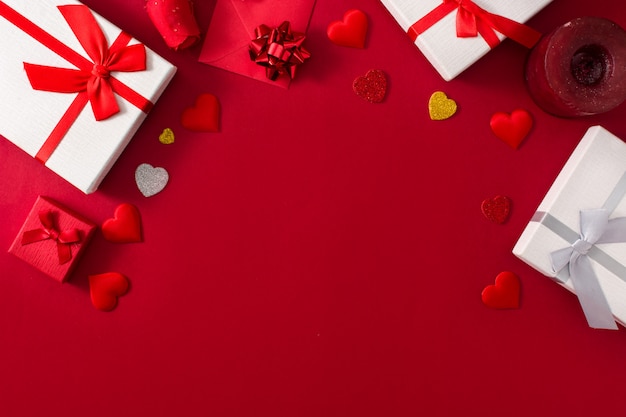 Cajas de regalo, sobre de papel rojo y corazones rojos.