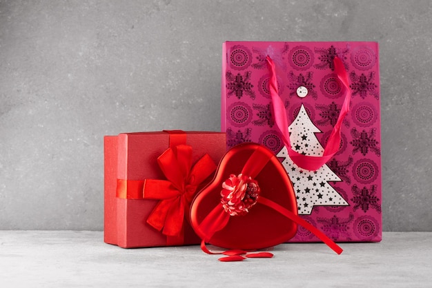 Cajas de regalo sorpresa roja con cinta en forma de corazón regalos con amor para el día de San Valentín o Navidad sobre un fondo blanco gris con textura