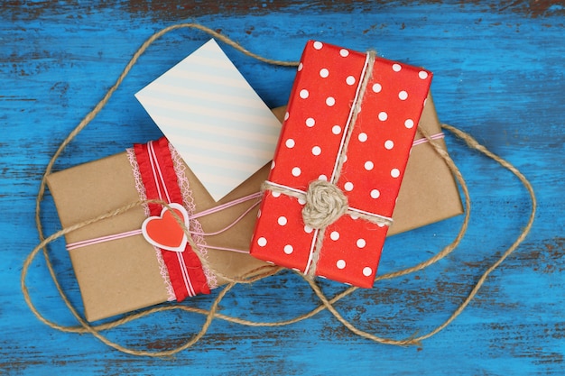 Foto cajas de regalo con tarjeta sobre fondo de madera