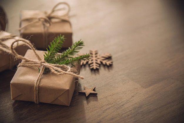 Cajas de regalo de temporada navideña con rama de abeto en la mesa rústica