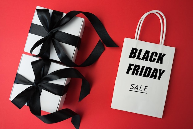 Cajas de regalos y bolsas sobre fondo rojo Ventas del Viernes Negro