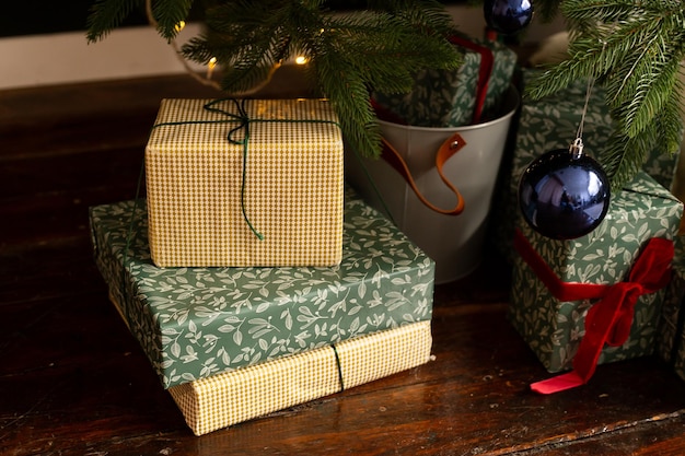 Cajas de regalos de Navidad bajo el árbol de Navidad con bolas de Navidad verdes, azules y rojas en casa