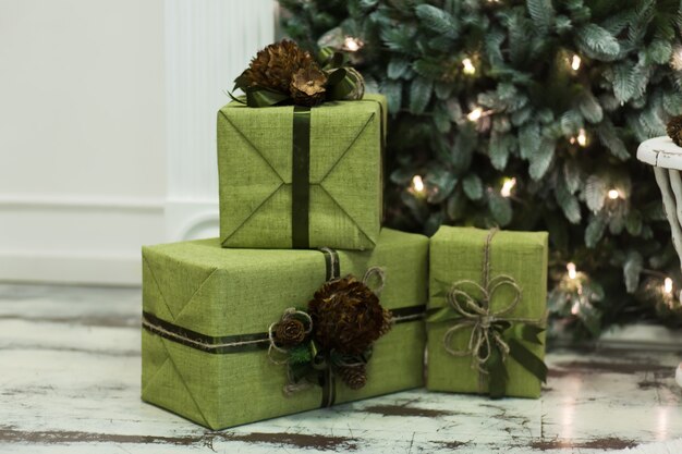 Cajas con regalos de Navidad envueltas en papel de regalo cerca del árbol de Navidad. Ambiente navideño.