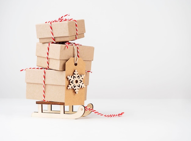 Cajas con regalos en un trineo sobre un fondo claro con espacio para texto Regalos para Año Nuevo y Navidad