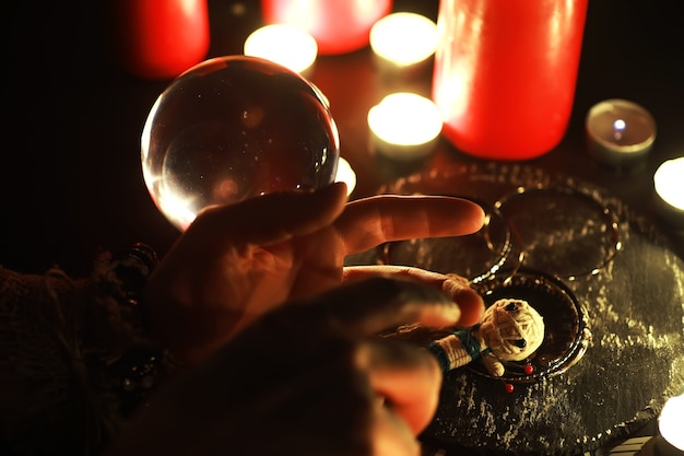 Cajero del futuro. Bodegón místico con muñeco vudú, las cartas del tarot, libros, velas malvadas y objetos de brujería. Rito de adivinación.