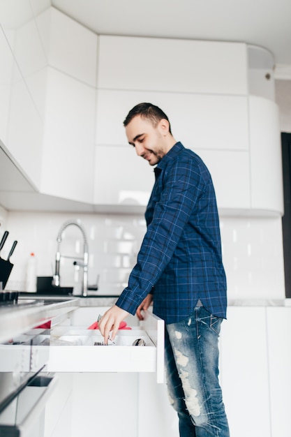 Foto cajón de apertura joven en la cocina