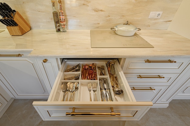 Cajón extraído en el gabinete en muebles de cocina clásicos de lujo en beige y oro