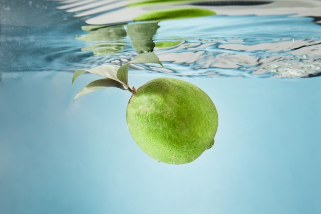 Foto la cal cae al agua creando salpicaduras en el agua.