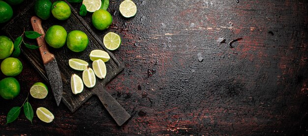 Cal cortada con hojas en una tabla de cortar con un cuchillo