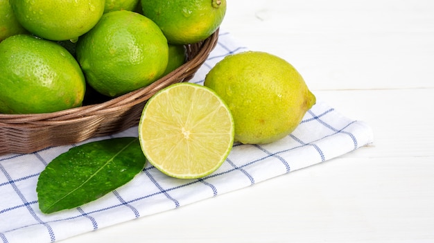 Cal verde em uma cesta em uma mesa de madeira branca.