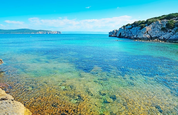 Cala Dragunara agua clara bajo un cielo azul