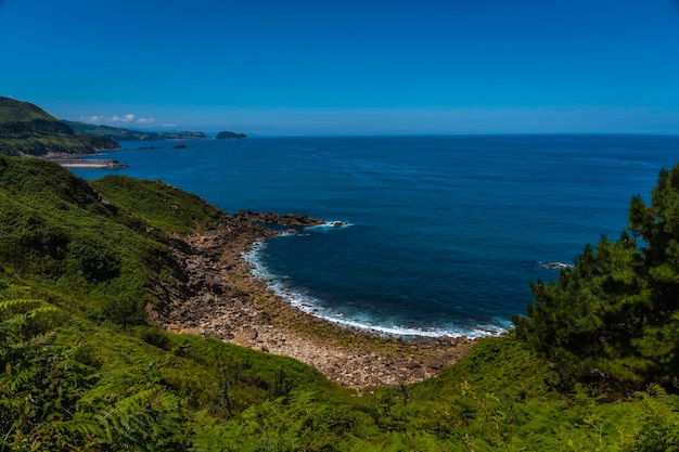 Cala escondida en la costa de Orio y en la distancia Getaria Guipuzcoa País Vasco