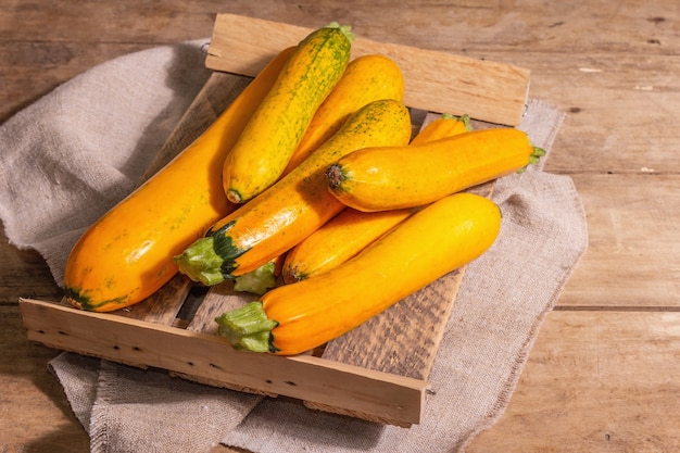 Calabacín naranja fresco. Cosecha de verduras maduras en un soporte de madera. Mesa de tableros vintage, espacio de copia